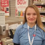 person smiling at camera behind cash register at Walgreens