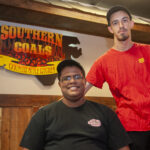 two people sitting in restaurant smiling at camera