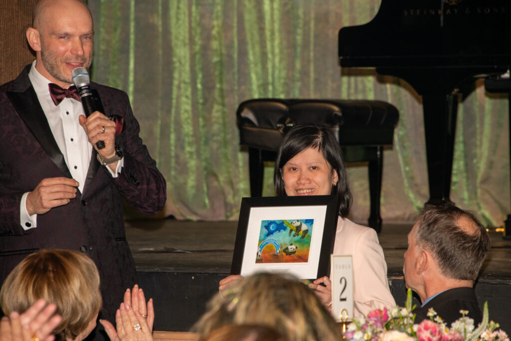 Woman holds up framed artwork