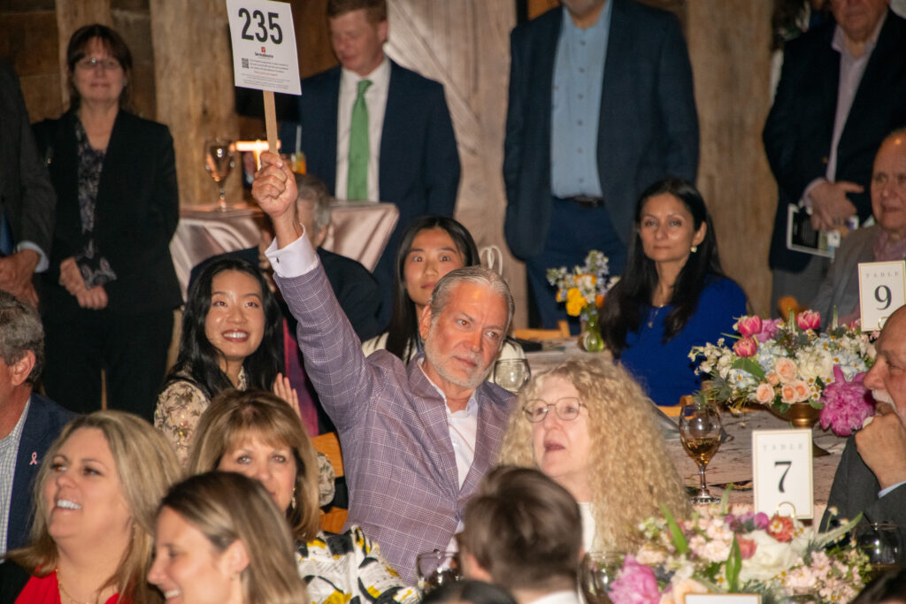 Man raises auction paddle in the air