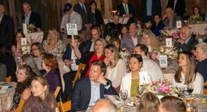 Woman raises auction paddle at fundraiser